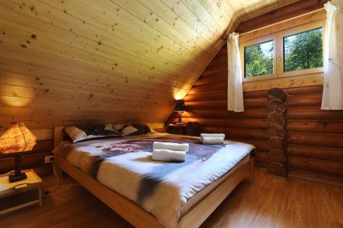a bedroom with a bed in a log cabin at Holiday house with a parking space Kuzelj, Gorski kotar - 20489 in Delnice
