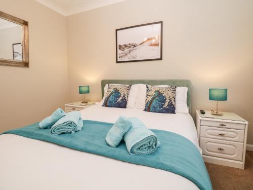 Un dormitorio con una cama con toallas azules. en Kempton en Bowness-on-Windermere