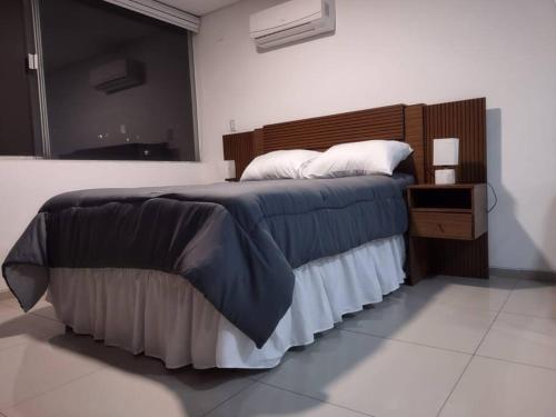 1 dormitorio con 1 cama grande y cabecero de madera en Monoambiente en Equipetrol, en Santa Cruz de la Sierra