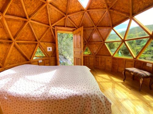 1 dormitorio con 1 cama en una habitación con ventanas en Colombia Mountain Tours Glamping and Cabanas en Choachí