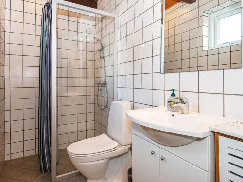 y baño con aseo, lavabo y ducha. en Holiday home Rømø CXXV en Rømø Kirkeby
