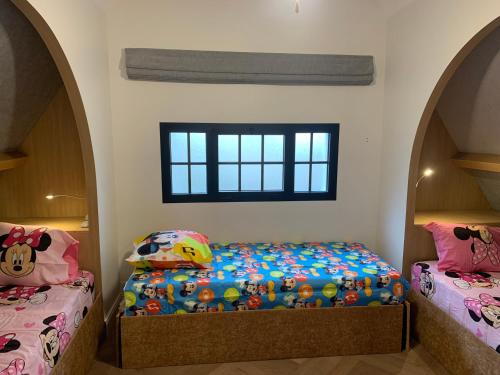 sypialnia z 2 łóżkami pojedynczymi i oknem w obiekcie Disney cottage w mieście Coupvray