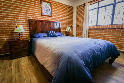 a bedroom with a bed and a brick wall at Cabaña para parejas en Zacatlán de las Manzanas 
