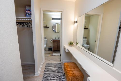 ein Badezimmer mit einem Waschbecken, einem WC und einem Spiegel in der Unterkunft The 07 Oasis in Fort Wayne