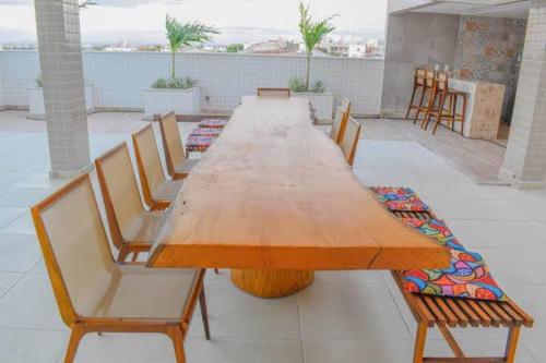 a long wooden table and chairs on a patio at Seller residence in Sobral