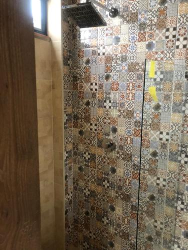 a bathroom with a shower with a tile wall at APTO 102 EN "ABADIA de TOMINE" in Guatavita