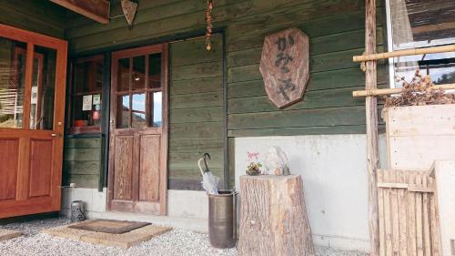 una casa di legno con un uccello seduto su un ceppo all'esterno di Washi Studio Kamikoya a Yusuhara