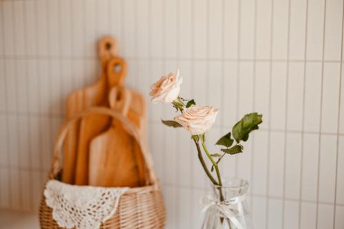 a vase with a flower in it next to a basket at Gyeongju Hanok Sohwa in Gyeongju
