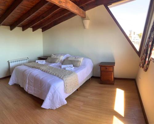 Un dormitorio con una cama grande y una ventana en La Torcida House en El Calafate