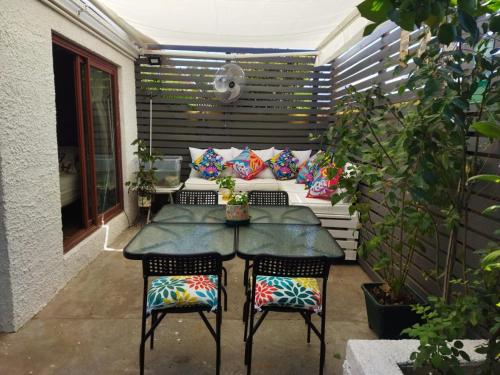 een kleine patio met een tafel en 2 stoelen bij Casa Roble Añejo Bed & Breakfast in Santa Cruz
