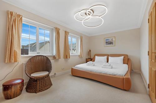 a bedroom with a bed and a chair and a chandelier at Taigh d'Luxe in Inverness