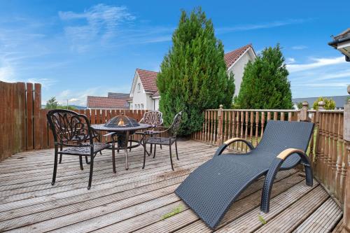 a deck with a table and chairs and a table and chairs at Taigh d'Luxe in Inverness