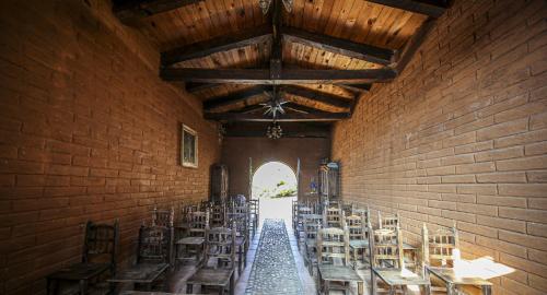 a hallway with tables and chairs in a brick wall at Huayápam Yù'ú Lodge in San Andrés Huayapan