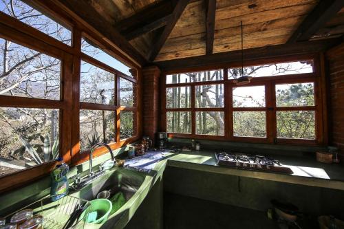a kitchen with a sink and windows in a cabin at Huayápam Yù'ú Lodge in San Andrés Huayapan