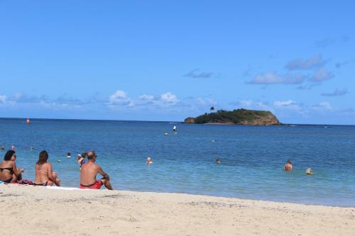 a group of people sitting on the beach at Le Colibri et le Frangipanier in La Trinité