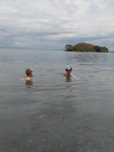 two people swimming in a body of water at Sapo Karo Rest House in Berastagi