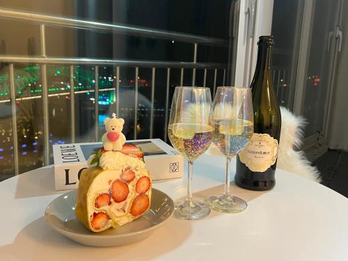 uma mesa com um prato de comida e copos de vinho em Tongyeong Canal Ocean View em Tongyeong