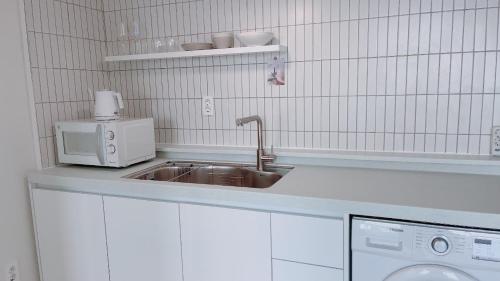a kitchen with a sink and a microwave at Tongyeong Canal Ocean View in Tongyeong