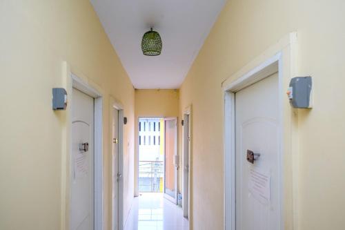 a hallway with white walls and doors and a ceiling at RedDoorz at Pengayoman Panakkukang 2 Makassar in Makassar