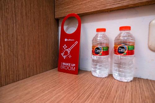 two bottles of water sitting next to a red tag at RedDoorz at Pengayoman Panakkukang 2 Makassar in Makassar