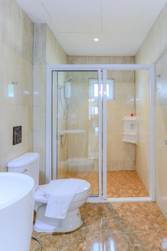 a bathroom with a toilet and a glass shower at Happy Land Residence in Ban Nam Cham