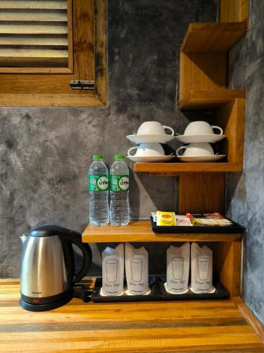 a shelf with two bottles of water and a tea kettle at Phi Phi Phu Chalet Resort in Phi Phi Don