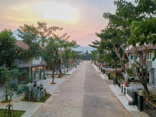 an empty street in a town with houses at Happy Land Residence in Ban Nam Cham