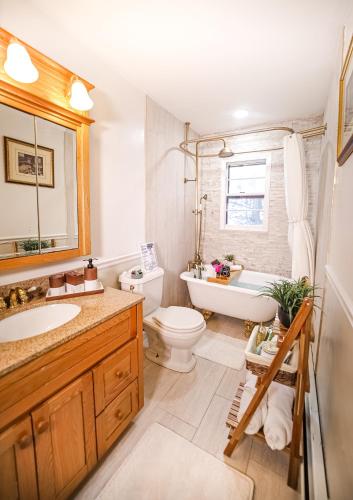 a bathroom with a tub and a toilet and a sink at Infinity MountView House in Sussex