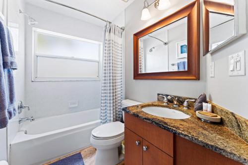 een badkamer met een wastafel, een toilet en een spiegel bij Enjoy a stress free vacation at this 3BR paradise in Sarasota