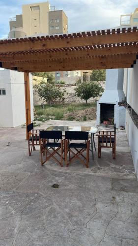 a picnic table and chairs under a pavilion with a fireplace at Depto Gales, a 1 cuadra del mar in Puerto Madryn