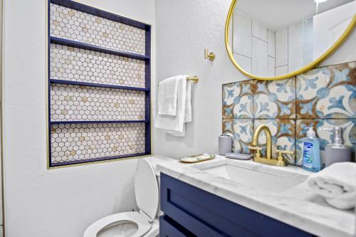 a bathroom with a sink and a toilet and a mirror at Chic and cozy private getaway! in Tampa