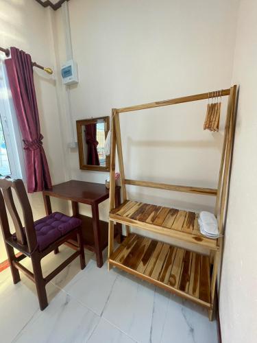 a room with a chair and a table and a mirror at เชียงคานพาราไดร์รีสอร์ท&มีตติ้ง in Ban Na Bon (1)