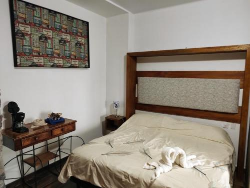 a bedroom with a bed with a wooden headboard and a table at Ex Hacienda Santa Elena in Atlixco