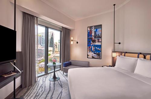 a hotel room with a bed and a large window at Pullman Singapore Orchard in Singapore
