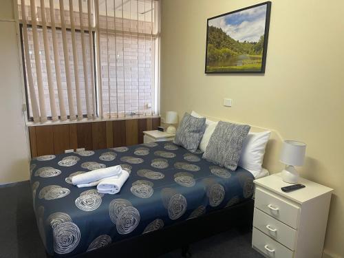 a bedroom with a bed with towels on it at Grand Central Motel in Mount Gambier