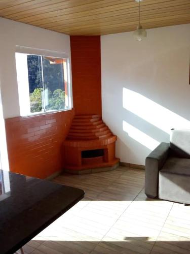 a living room with a couch and a window at Bangalô - Sítio Cachoeiras do Caledônia in Nova Friburgo