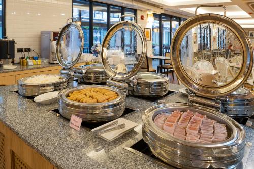 een buffet met hotdogs en andere etenswaren op de bar bij Darley Hotel Chiangmai in Chiang Mai