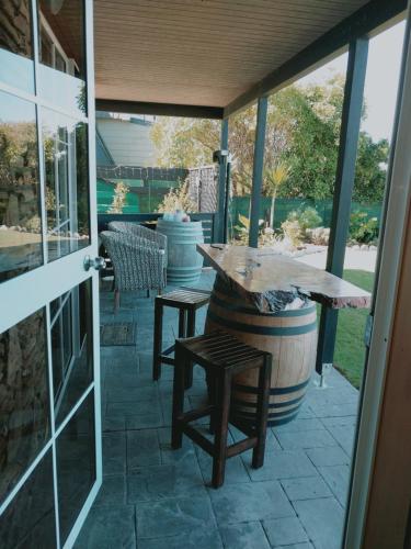 a patio with a table and chairs and a barrel at Rarangi Seaview On the Beach B&B in Blenheim