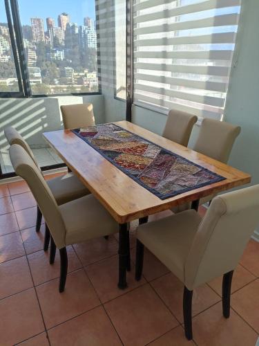 a dining room table and chairs with a view of the city at Solvallerios Apartments in Viña del Mar
