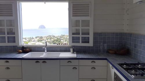 a kitchen with a sink and a large window at VILLA KARAT in Le Diamant