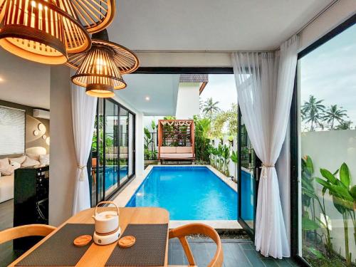 a villa with a swimming pool and a dining table at Asri Cinta Villa Ubud in Ubud