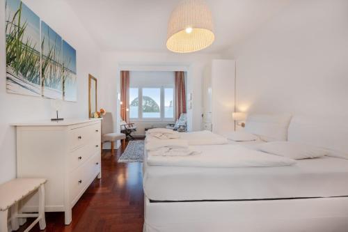 ein weißes Schlafzimmer mit 2 Betten und einem Schreibtisch in der Unterkunft Villa Meereswoge - Goldstern in Bansin