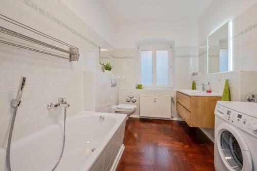 a white bathroom with a tub and a washing machine at Villa Meereswoge - Goldstern in Bansin