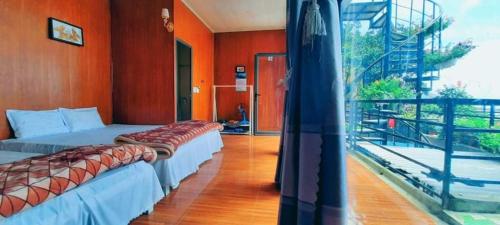 two beds in a room with a balcony at Daisy Homestay Tam Dao - Venuestay in Vĩnh Phúc