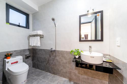 a bathroom with a sink and a toilet and a mirror at Đà Lạt Cao Nguyên Hotel in Da Lat