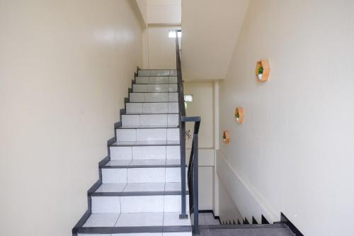 a staircase in a building with grey tiles at RedDoorz @ Jalan Pramuka Manado in Manado