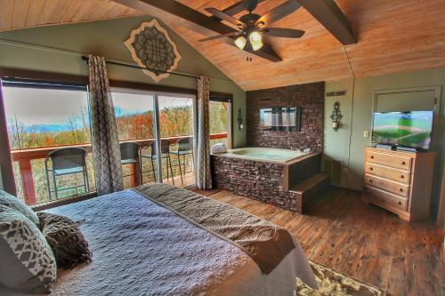 a bedroom with a bed and a television and a tub at Paradise Vista, Amazing Mtn Views, Hot Tub, 560 FREE tickets each paid day!!! in Gatlinburg