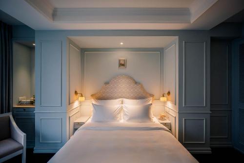 a bedroom with a large white bed in a room at Le Jardin Hotel Haute Couture in Hanoi