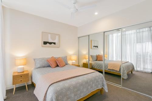 a bedroom with two beds and a mirror at Cabarita Beachside - 1st Floor 2BR Apt by uHoliday in Cabarita Beach