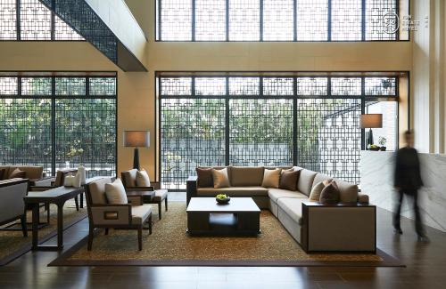 a living room with a couch and chairs and windows at 蘊泉庄 Yun Estate Hotel in Tamsui